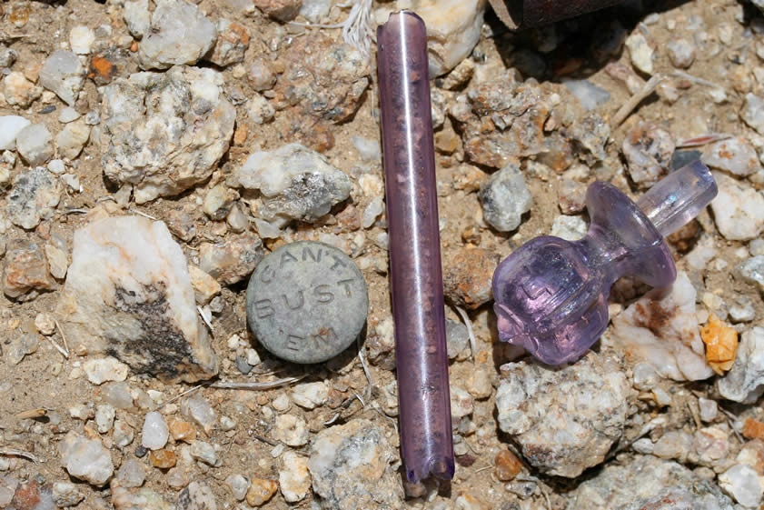 Some purple glass and a metal clothing fastener.