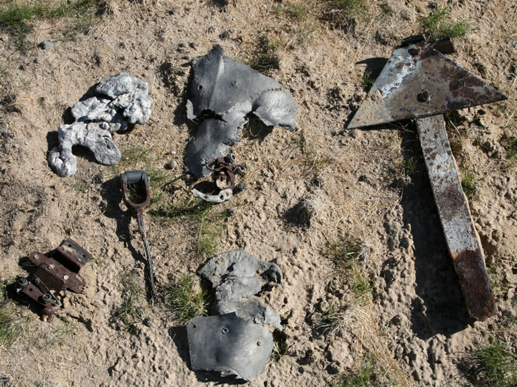 Even a cursory search will turn up pieces of riveted aircraft aluminum skin, control wire with fittings, and old runway markers such as those seen here.