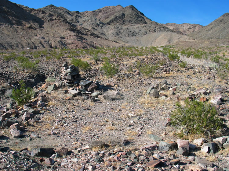 We don't get very far, though, before another enigma presents itself.  Here, at the edge of the wash, is a stone cairn, a rough rock outline, and another can scatter.