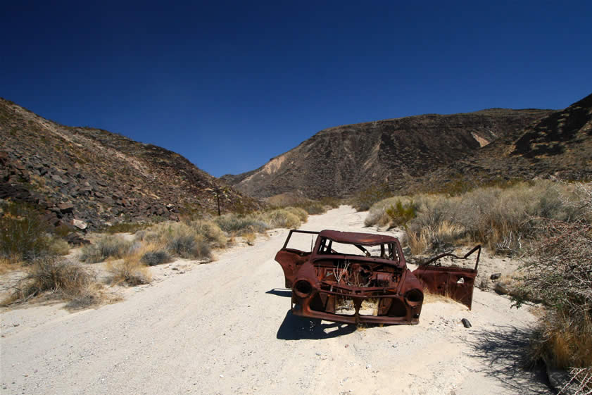 As we hike further along the wash we come to the rusted remains of a car.