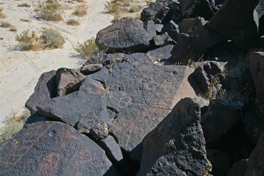 When we climb up to the top of the outcrop we're surprised to find that the flat surfaces have also been inscribed.