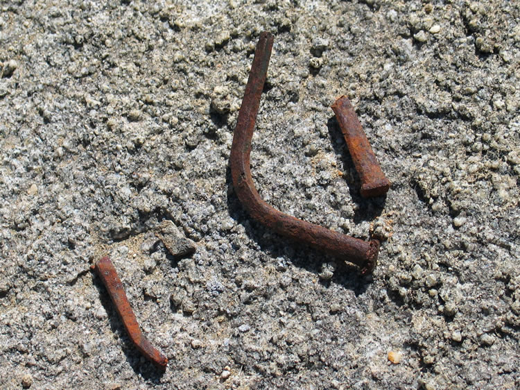 We find nearby a few square nails that have a hand made appearance.