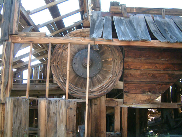 This is the large wooden fly wheel of the stamp mill.