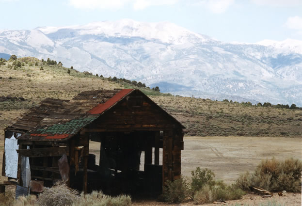 Outbuilding with dry lake in background.