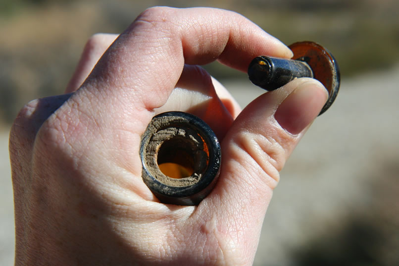 The glass stopper was encased in cork, which has now adhered to the neck of the bottle.