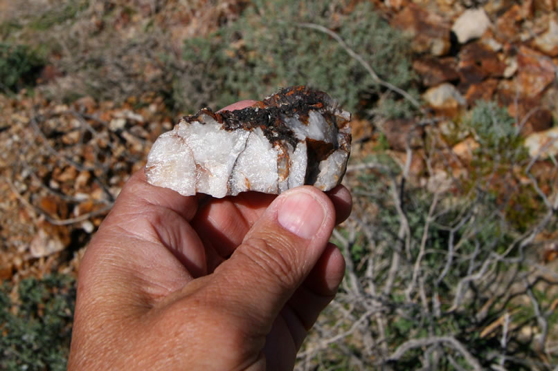 An interesting bit of quartz with a crust of a dull grey metallic looking substance.