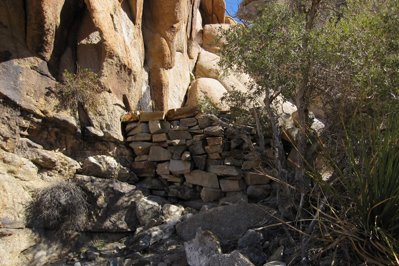 This is a view of the stacked rock retaining wall from the outside of the blacksmith area.