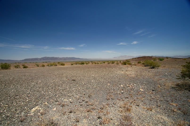 Shortly after leaving the Mystery Mine, our route to the Blind Mule Placer takes us across a small, elevated "island" that rises out of Pinto Basin.  We call it Shark Island because of the distinctive tall, dark rock outcrop that looks very much like the dorsal fin of a shark.