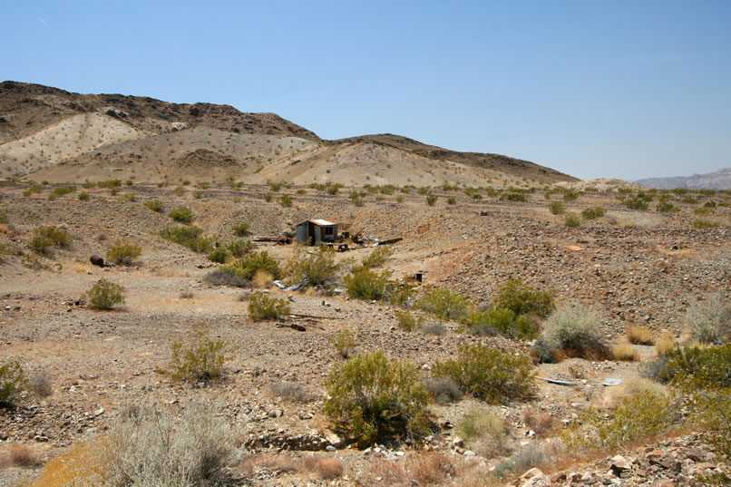 After some anxious minutes of double checking the GPS and wondering if we're wrong about the existence of this cabin, we finally catch a glimpse of the top of its roof nestled down below the level of the bajada and edge closer to get this view of it.  Hey, we found it!  After a short "we found the cabin" dance, we head over to check it out.