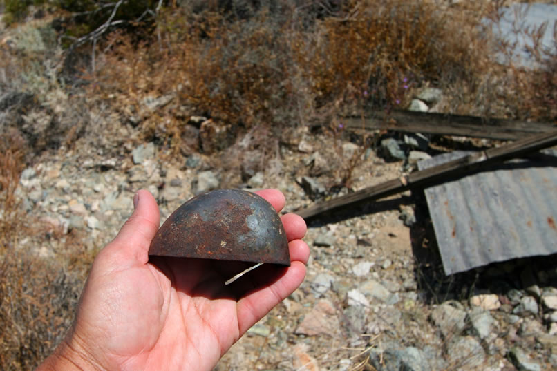 In front of the cabin is a large area of old junk. There's also a collapsed outhouse.  Here's the metal toe box to a steel toe boot.  In the next photos are some images of a small bit of the junkyard.