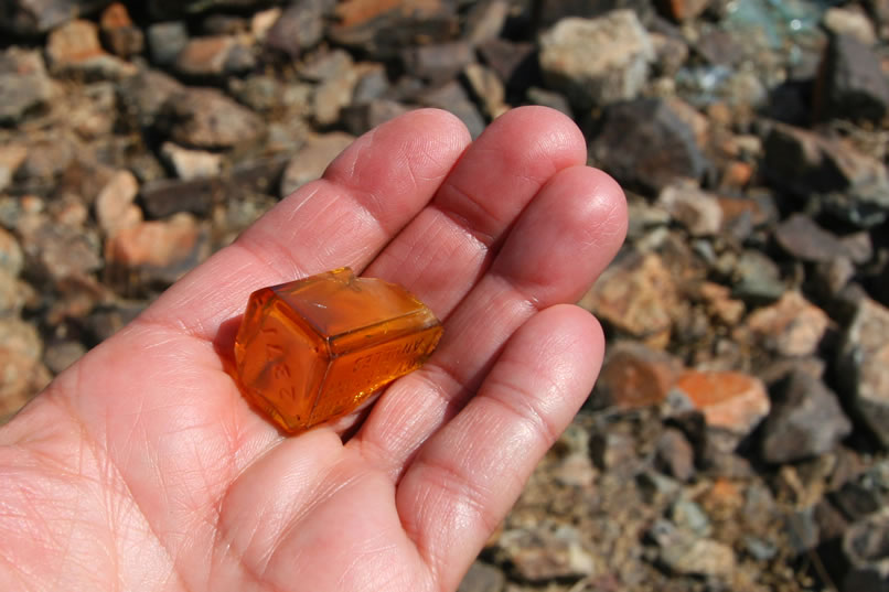 This small, amber bottle fragment is found wedged into the rock foundation.