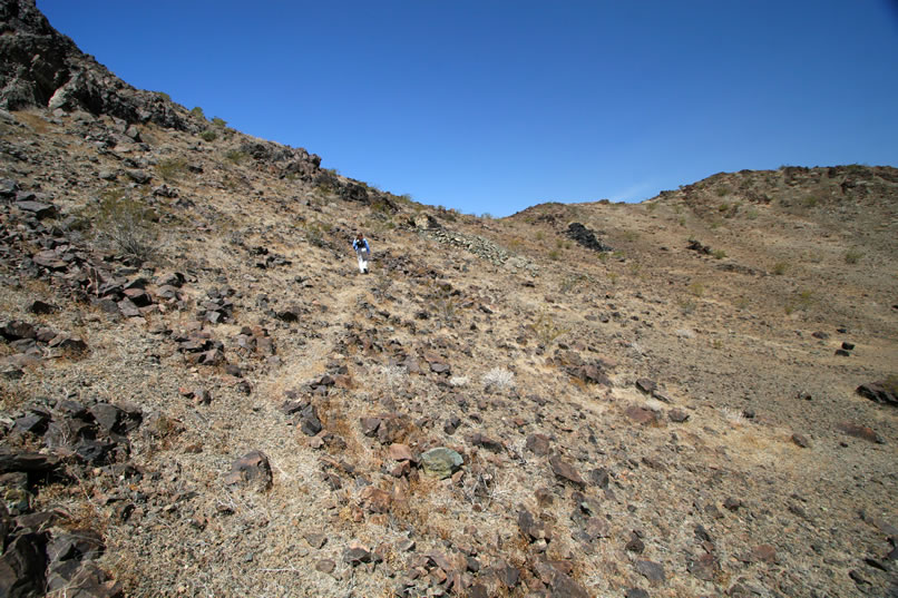 Next, we want to take a look at the adit that we had seen on the hillside as we approached the mine site.  Here's a view of Niki on her way up.  