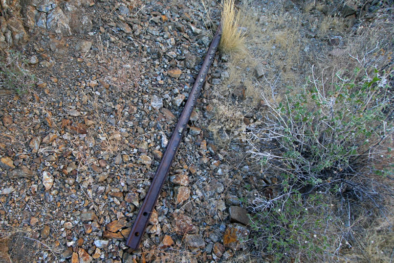 One of the ore cart rails sticks out from under the collapsed tunnel entrance.