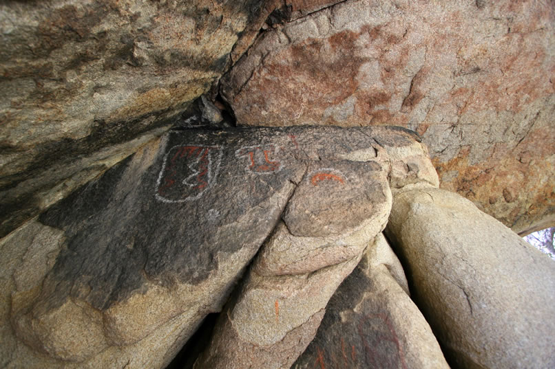 High up near the ceiling of the shelter are some striking orange and white pictos.  In the lower right of the photo you can also see some solid red elements.