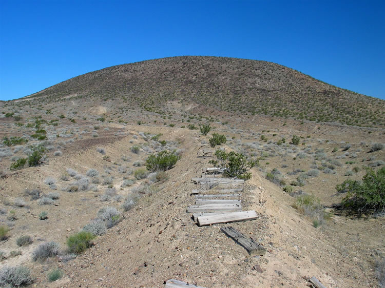 About a half mile before the mine area, the topo map has a notation for a dike.  We swing over to check it out and find that the dike seems to have the remains of a trackway on top of it.