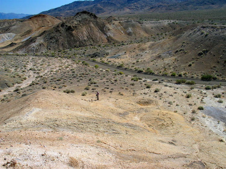 Jamie is still taking pictures of shovel parts down below.  To the right of her is a small crater that's probably an impact crater from errant munitions.  They're all over the place.