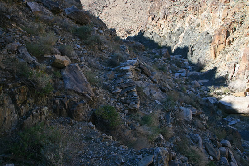 Niki soon finds herself on an eroded and slick path high on the hillside above the wash.  Being a mountain gal, she's used to this type of terrain and proceeds cautiously.