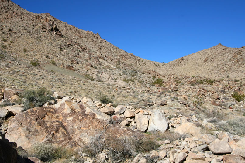 At the left center of the photo you can see the greenish tailings pile from the main adit of the mine.  It's time to climb out of the wash and head over toward the mine.