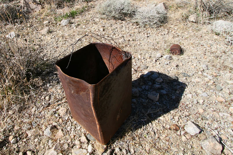 It looks like this tin has been fitted with a wire bail so that it can be filled with water and hung to form a shower.  The next photo shows the holes that have been punched in the bottom of the tin to release the water.