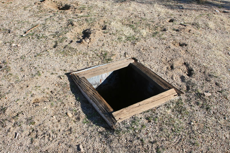 We're not too sure of the purpose for this metal lined shaft.  Uses such as outhouse pit, shallow well or cool storage come to mind.