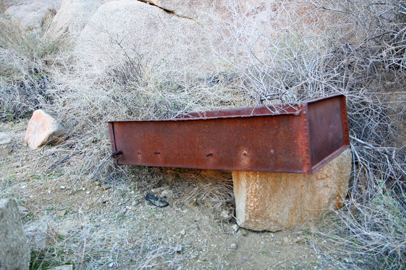 There's also a shallow metal object that now seems to be a repository for old cans and metal parts.