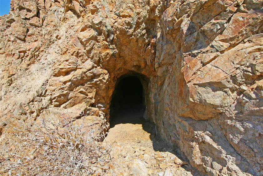 Further down the wash, at the junction with another wash, we stumble on a tunnel entrance.  This one looks in good shape so we take a look inside.