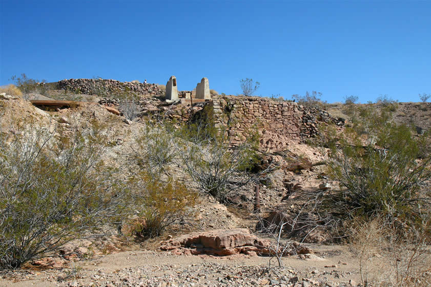 Howard, who was hiking along the rim of the wash, lets us know via radio that he's found the mill.  We hustle down the wash for another quarter mile or so and see the mill ruins built into the hillside.   Before we explore it, though, Howard suggests that we continue down the wash a ways to see a really colorful rock formation.