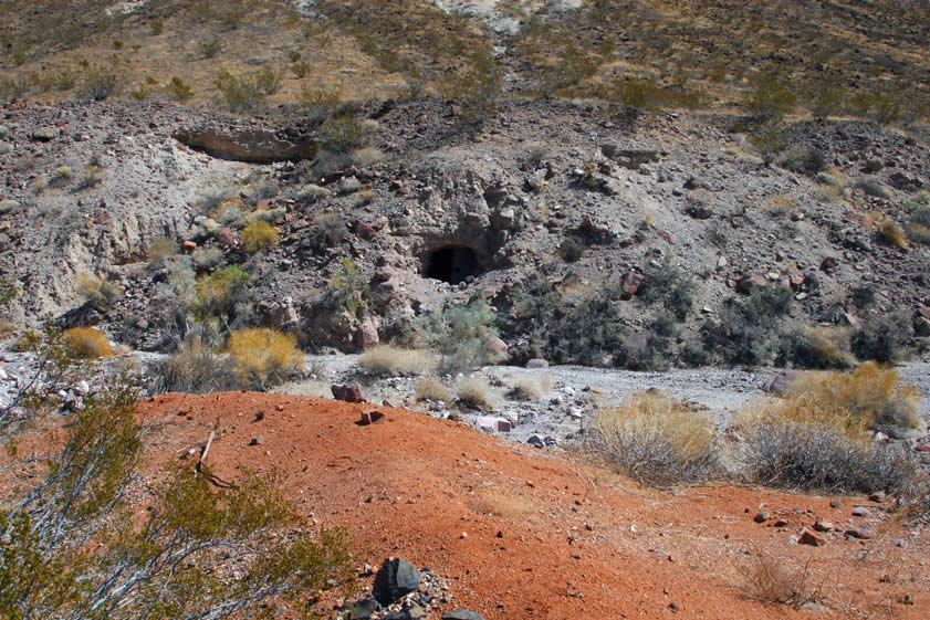 The reddish colored tailings in the foreground lead us to the first evidence of the mining operation.  It was in 1909 that the mining journals first report a force of 30 men working here.  We head over to take a closer look at the tunnel.