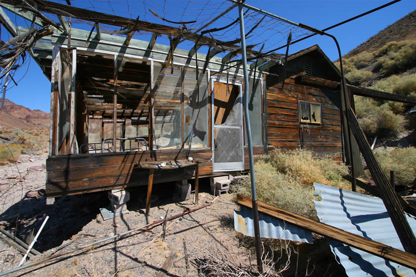 Notice the new screen door and the remains of netting and interwoven palm fronds to create a shade cover.