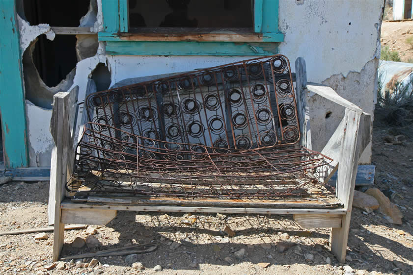 In a typical stroke of creative desert genius, it appears that the front seat springs from an old car have been used as a cushion on the bench outside the guest house.