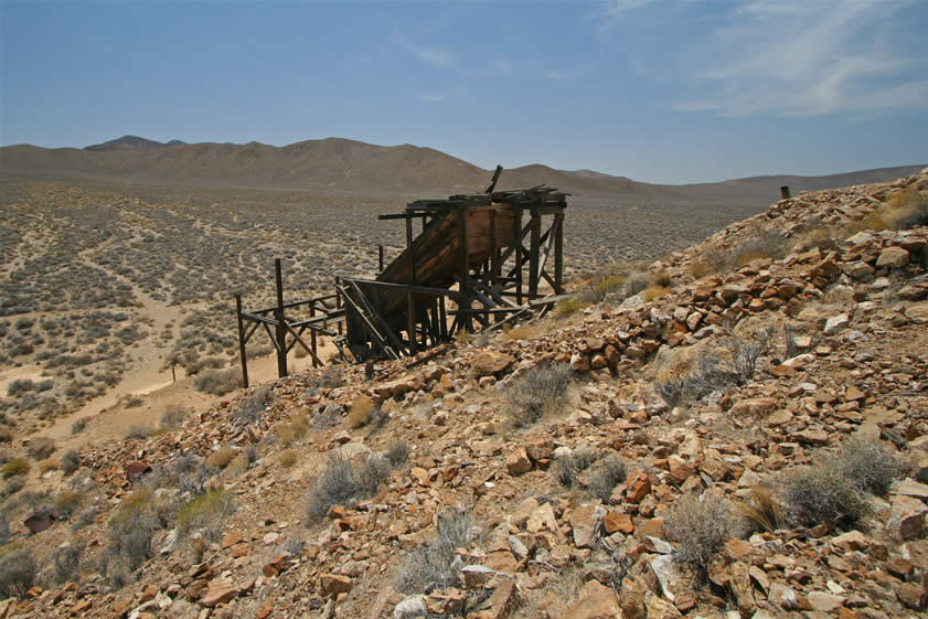 The ore bin and chute which brought ore down to the three level mill can be seen in this photo.