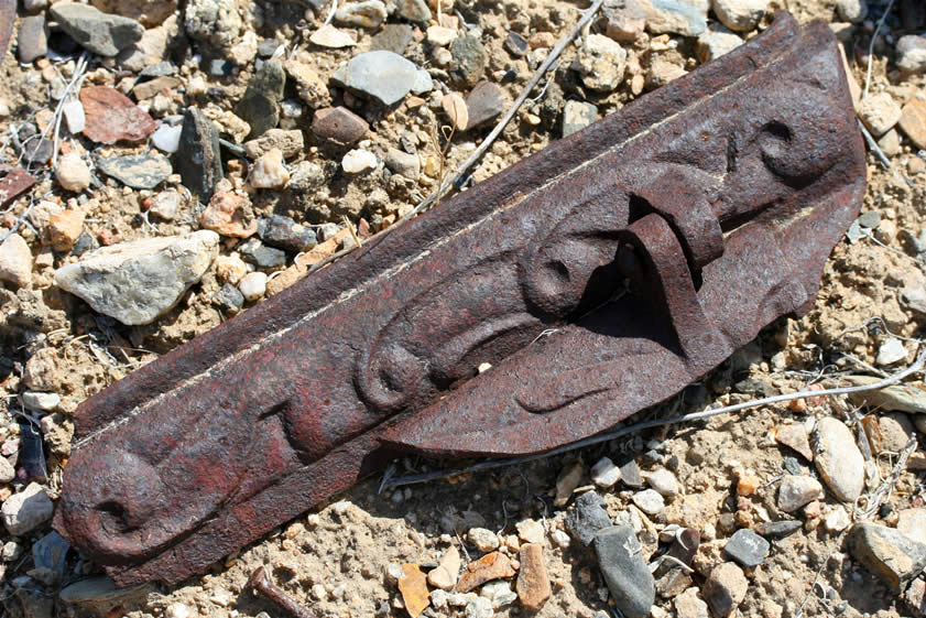 An ornate fragment from a heavy cast iron stove.