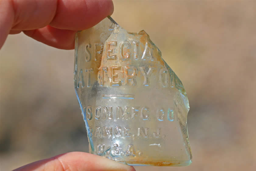 This little bottle fragment is a nice find, although we have no idea what it would be doing here.  It's from a small bottle of Special Battery Oil.  This product was patented in 1908 and was made by the Edison Mfg. Co., Orange, N.J.  This Thomas A. Edison oil was a special nonconductive oil that would have been added to the top of an old glass jar battery cell.  Inside the jar would be zinc and lead plates, caustic soda and water and then the oil was added to the top of the cell to prevent evaporation.  These cells were often used by railroads to operate signal circuits.  Although there are no railroads near here, we're sure that these old miners found a use for this product!