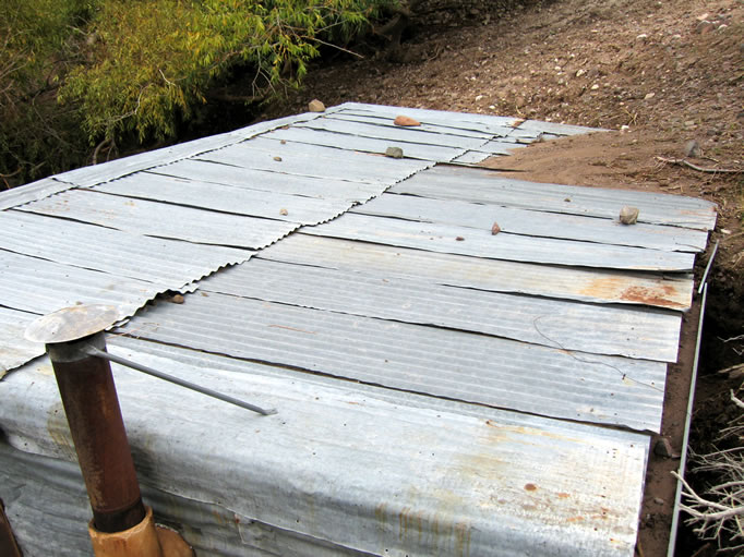 The hillside behind it is soft earth.  When it rains it turns to mud.  Here you can see a mud flow on the roof.