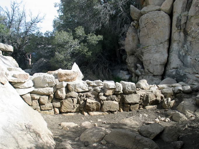 A low rock and mortar wall, possibly part of a water catchment system for the Wonderland Ranch.