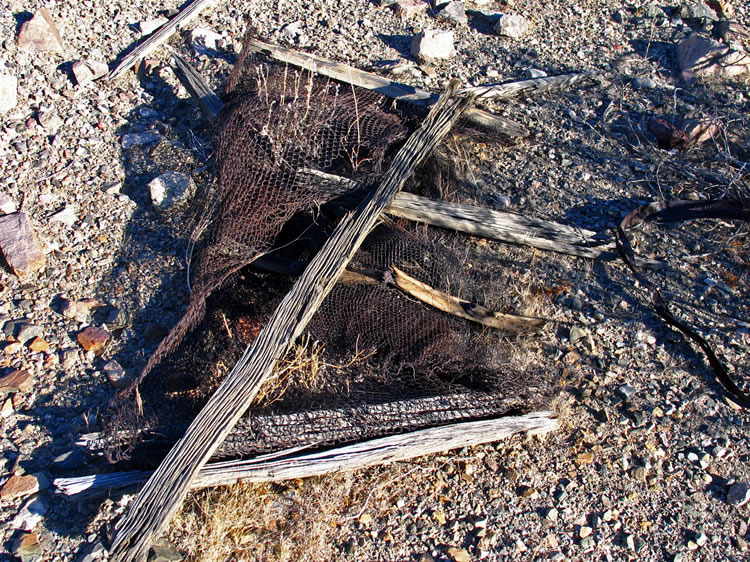 A crude woven wire mattress is found nearby.