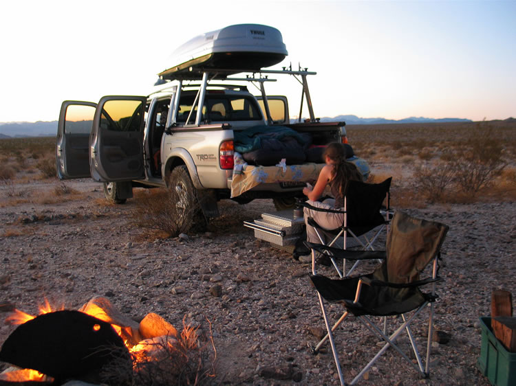 With a cheery fire crackling and the sleeping bags laid out and ready in the truck bed, Niki works on dinner.  Our stomachs are growling!