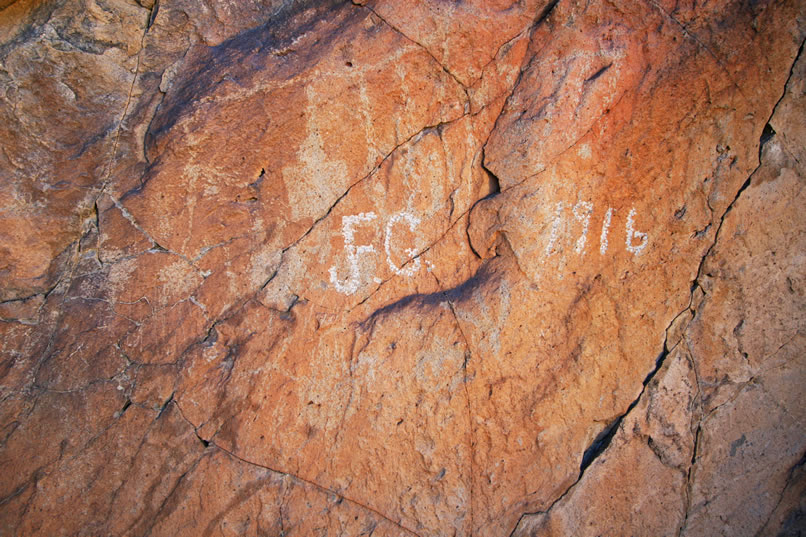 In this closer view you can see that the inscription is placed over some very old looking petroglyphs.  There are also numerous other very faint glyphs on this rock face.