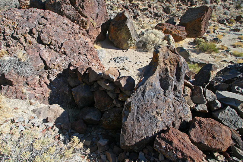 Even a quick first glance shows that there's a lot going on here.  To begin with, there are stacked stone walls between some of the boulders that might have been either prehistoric hunting blinds or used historically for walling in cattle or horses.  There also seems to have been a spring or seep near one of the larger boulders and looming over everything are lots of  petro panels.