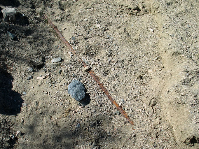 Erosion in the wash has uncovered an old pipe, possibly once the conduit bringing precious water to the Eldorado Mine in the distant Hexie Mountains.