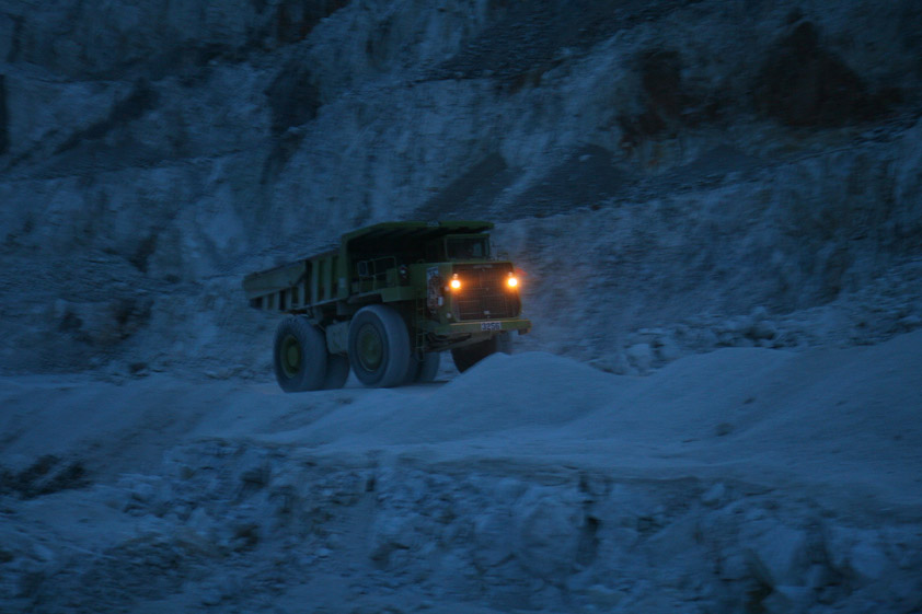 One of the big earth movers rumbles by over on the haul road.  As it passes we turn off our flashlights and push the switch on the black lights to bathe the rocks in an eerie purple glow.
