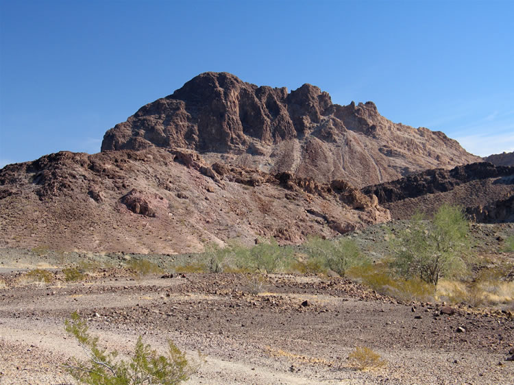 The western face of Thumb Peak looms large as we near the end of the black agate location.  It's here that the old road turns toward the south.  We're about to follow it but get sidetracked when we spot a distant rock shelter.