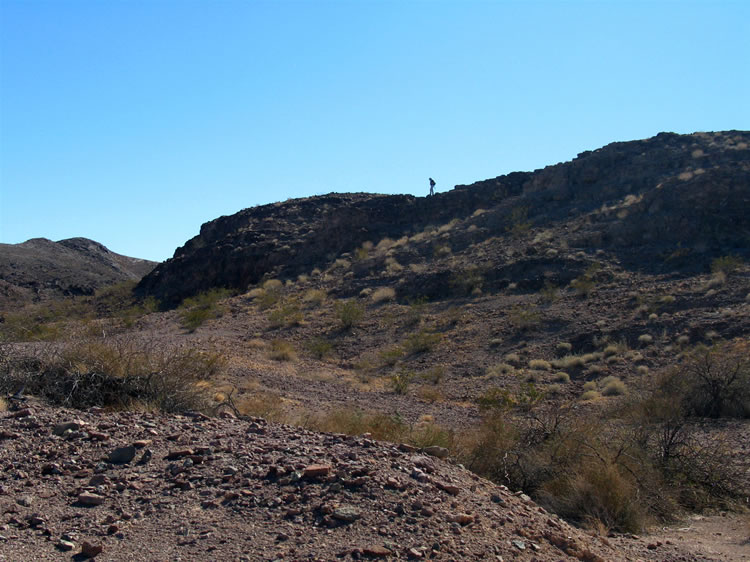 Niki makes a detour to try to get a photograph of the Indian shelters from the rim of the canyon across from them.