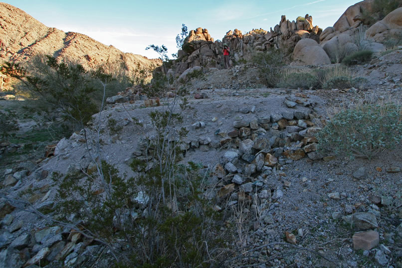 Scrambling up out of the wash brings us to an area where mine tailings have been used as fill between stacked stones to build up level spots.