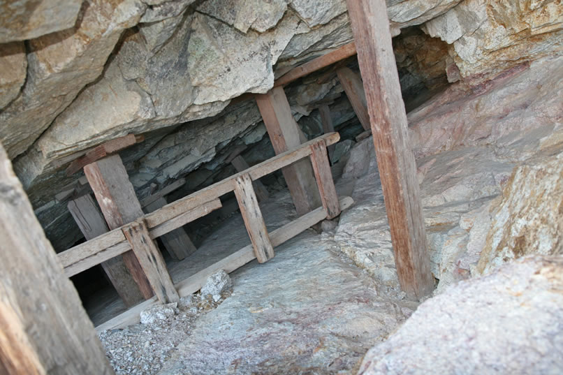 Nearby is a large tailings pile and then we spot the long stoped ledge that they had been working.  Notice the rough ladder leaning against the supports.