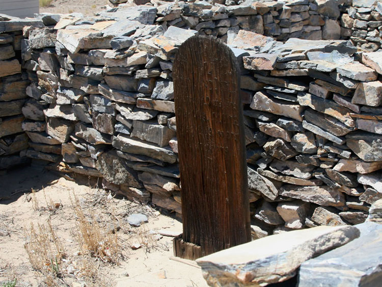 This carved wooden grave marker is no longer readable.