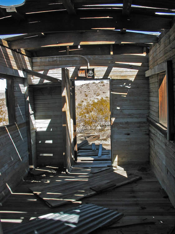 The hardwood floors and walls and the gently curved roof beams, as well as the long rectangular shape, seem to point to old mail or baggage cars.