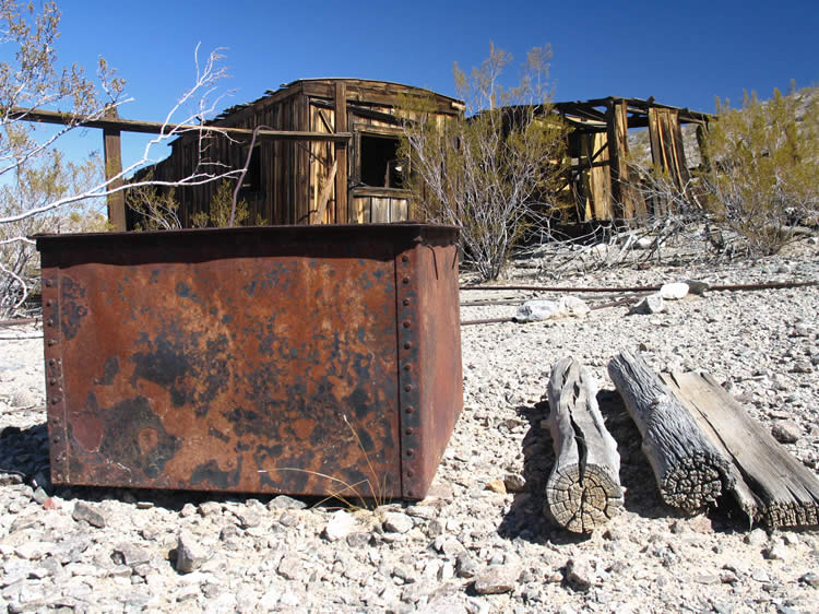 The stout metal tub near the cabins appears to be a type of ore carrier.  Notice the wood nearby.  We initially thought that they had brought in a lot of wood for fences and so on but as we leave the cabin area we're in for a surprise.