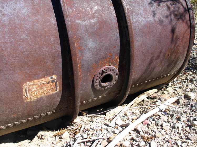 A large riveted barrel with rolling skids around its circumference.