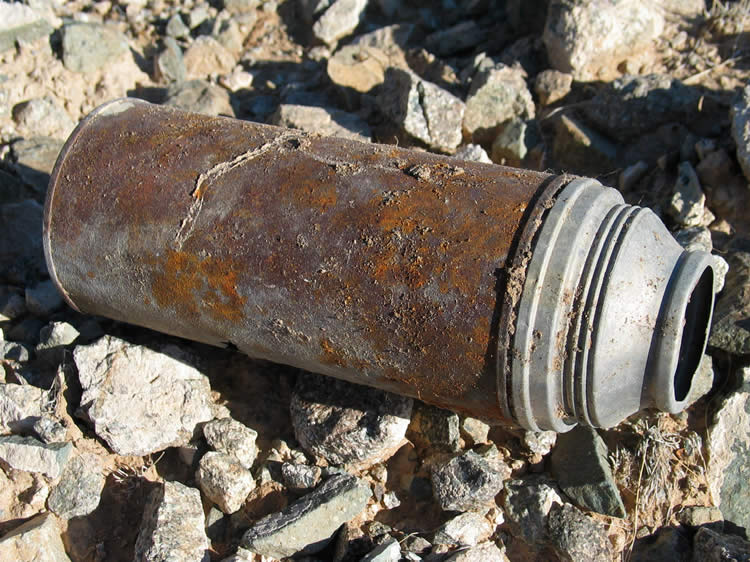 We leave a colorful rock sample that we found at the mine for Joe to check out and wander up to the crest of the hills by the wash to have a look around.  On the way we find an old Pen-I-Vac vacuum bottle.